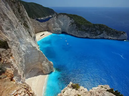 Widok na zatokę wraku Zakynthos z klifu. Turkusowa woda, biała plaża i wrak statku.