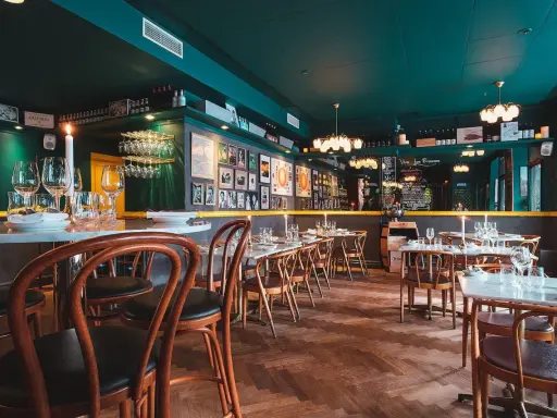 Mysig sydamerikansk restaurang i Stockholm med mörkt gröna väggar, trägolv och dukade bord.