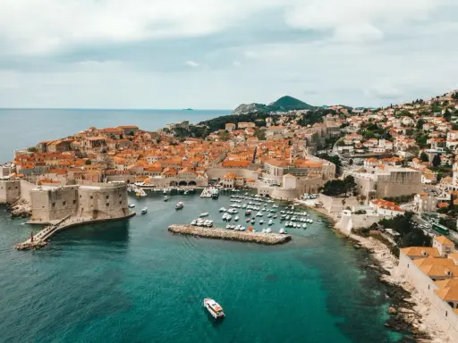 Aerial view of Dubrovnik's historic walled city and harbor, a beautiful destination for a gay vacation.