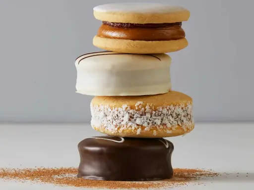 Una pila de alfajores, dulces típicos de Argentina y Uruguay, cubiertos de chocolate, coco y glaseado.