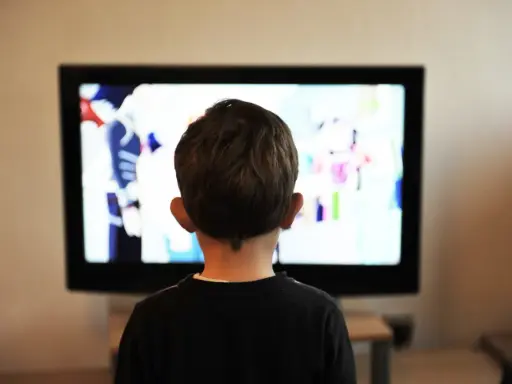 Un jeune enfant de 2 ans, absorbé par un dessin animé coloré sur le téléviseur.