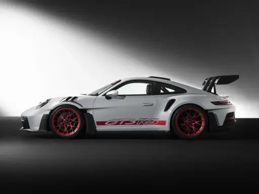 Weißer Porsche GT3 RS mit roten Felgen und Schriftzug. Ein Sportwagen, der Leistung und Eleganz vereint.