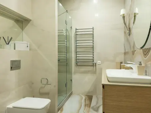 Baño moderno con ducha de cristal, lavabo y WC. Ideal para instalar extractor baño y mantener el ambiente fresco.