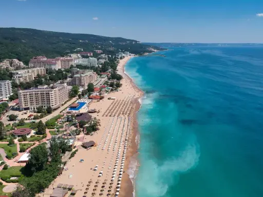 Bułgaria, Złote Piaski: widok z lotu ptaka na szeroką plażę z leżakami, hotele i park rozrywki. Idealne miejsce na wakacje!