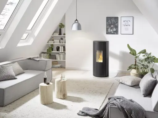 Poêle à granulés Rika en mode confort ou automatique, dans un salon moderne avec canapé gris, table basse en bois et lumière naturelle.