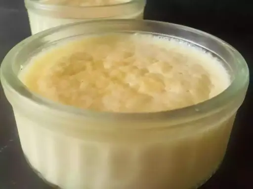 Deux ramequins de semoule au lait, un dessert crémeux et réconfortant, prêts à être dégustés.