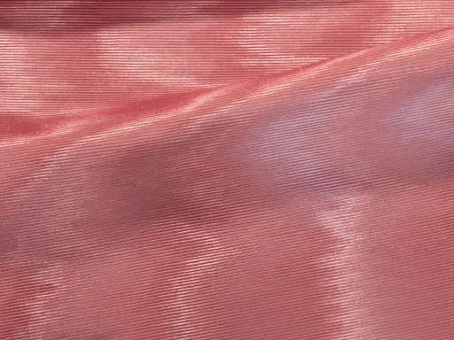 Tessuto rosa con pieghe che creano un affascinante effetto moiré, riflettendo la luce in modo cangiante.