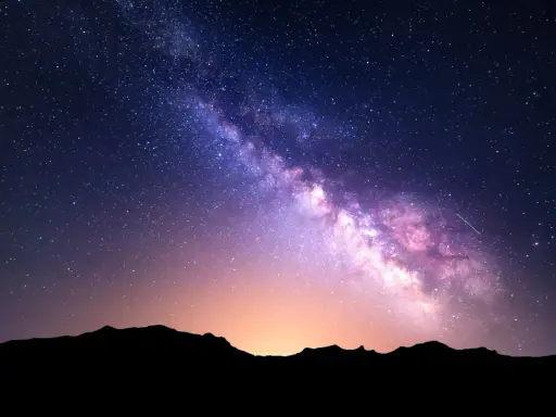 Droga Mleczna rozświetla nocne niebo nad Górami Stołowymi, tworząc magiczny widok w izerskim parku ciemnego nieba.