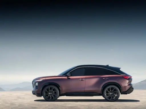 Eleganckie, bordowe infiniti auto z czarnym dachem na tle górskiego krajobrazu.