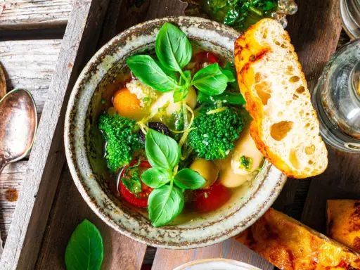Herzhaftes Minestrone Rezept mit frischem Gemüse, Kräutern und knusprigem Brot.