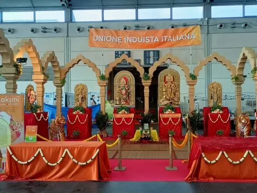 Allestimento per il festival dell'oriente Rimini con statue induiste, archi in legno e un grande striscione "Unione Induista Italiana".