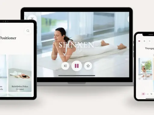 En kvinna utför morgon yoga på en matta. Skärmar visar yogaövningar och pass.