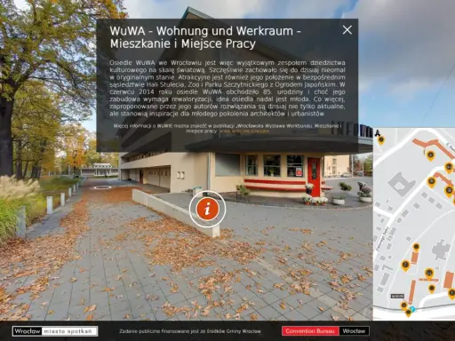 Jesienne liście na chodniku przed osiedlem WuWA we Wrocławiu. W tle budynek i drzewa. Mapa pokazuje rozmieszczenie budynków.