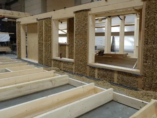 Holzkonstruktion mit Strohballenwänden im Bau. Die natürlichen holz eigenschaften machen es zu einem idealen Baustoff für nachhaltige Häuser.