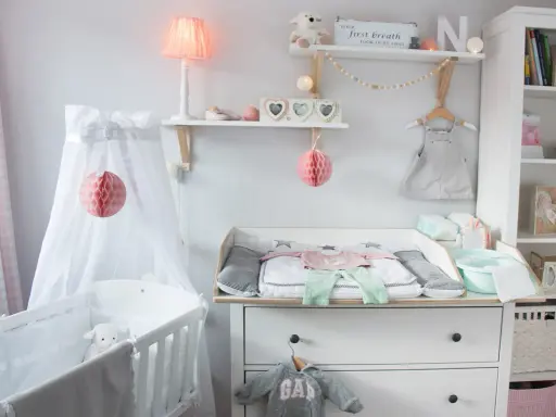 Eine liebevoll eingerichtete Hemnes Wickelkommode mit Babykleidung, Spielzeug und Deko.
