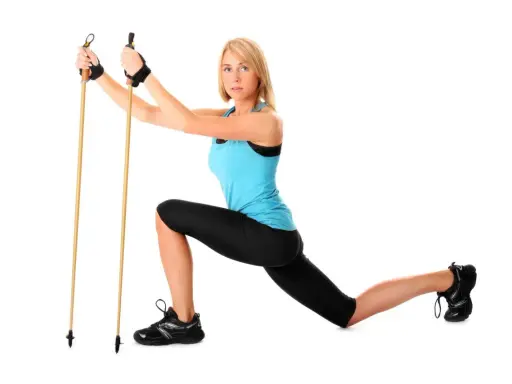 Kobieta w stroju sportowym demonstruje ćwiczenie z kijkami do nordic walking, pokazując, jak ustawić kijki do nordic walking.