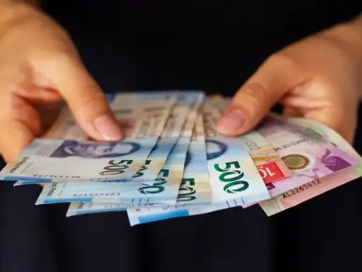 Manos sostienen billetes de 500 pesos, una forma de sacar dinero sin tarjeta.
