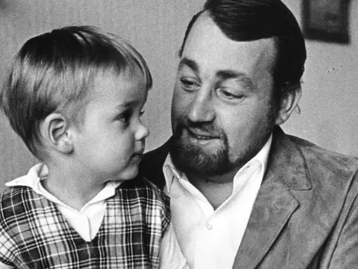 Cornelis Vreeswijk med sitt barn i en rutig väst. En varm stund mellan far och son.