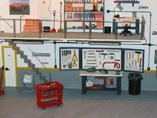 Un taller listo para organizar. Herramientas, estanterías y un coche en miniatura.