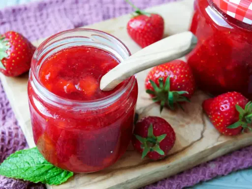 Frische Erdbeeren und selbstgemachte Marmelade in einem Glas. Perfekt zum Marmelade einfrieren für den Winter.