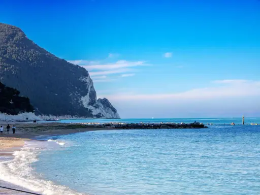 Spiaggia con scogliere e mare azzurro, ideale per scoprire dove andare al mare nelle Marche.