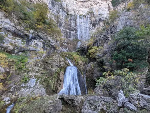 Impresionante cascada en la ruta de las cascadas Bogarra, cayendo por una pared rocosa con vegetación otoñal.