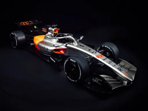 Ein silberner und oranger Audi F1 Auto mit dem Audi-Logo auf dem Heckflügel.