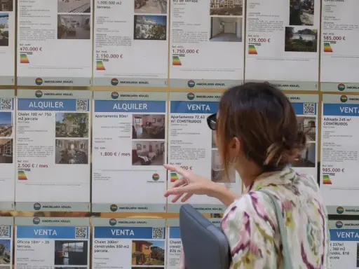 Mujer señalando anuncios de alquiler y venta de inmuebles, buscando opciones para el bono joven alquiler.