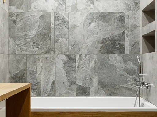 Schemi posa piastrelle 60x120 bagno: un elegante rivestimento in gres effetto marmo grigio crea un'atmosfera moderna e rilassante.