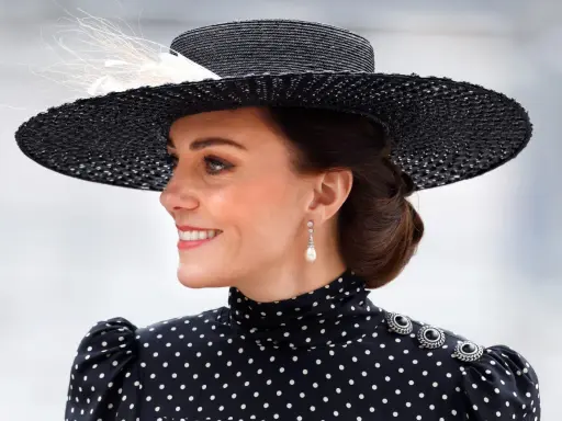 Księżna Kate w eleganckiej, czarno-białej sukience w grochy i stylowym kapeluszu.
