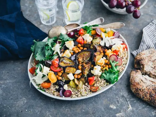 En härlig bowl med quinoa, kikärtor, tomater, fetaost och härligt grillad aubergine. Serveras med gott bröd och vatten med citron.