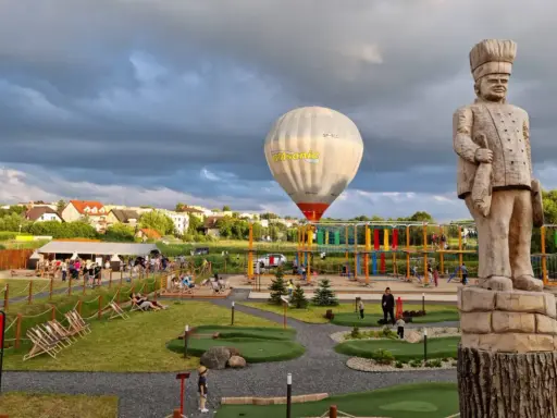 Wielki drewniany kucharz i balon na gorące powietrze nad placem zabaw i mini golfem. Kościerzyna atrakcje dla dzieci oferują mnóstwo zabawy.