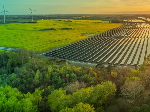 Weite Landschaft mit Windrädern, Solarpanels und grünen Feldern. Ein Zeichen für gesellschaftliche Akzeptanz erneuerbarer Energien.