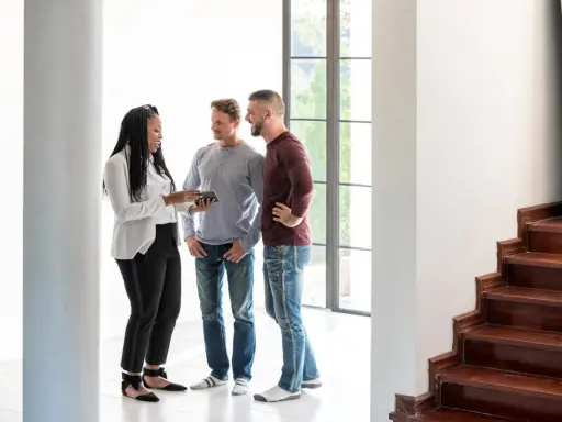 Un agent immobilier montre un appartement à un couple. La question se pose : peut-on louer un appartement seul quand on est marié ?