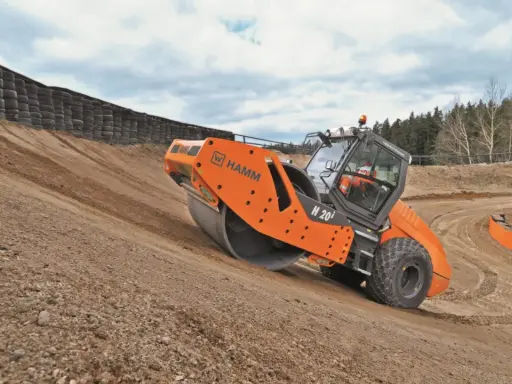 Rodillo Hamm H 20i trabajando en una pendiente, realizando la compactación del suelo.