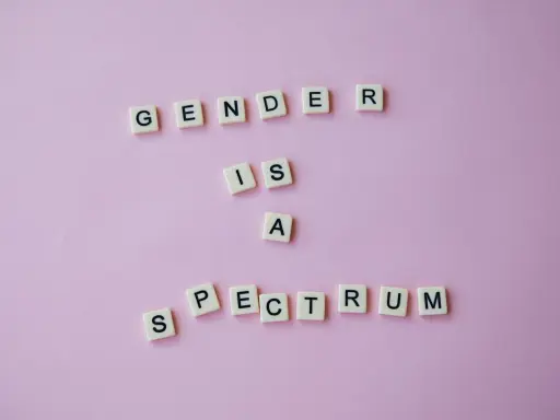 Litery układają napis "GENDER IS A SPECTRUM", podkreślając, że dysforia i niezgodność płciowa są częścią szerokiego spektrum tożsamości.