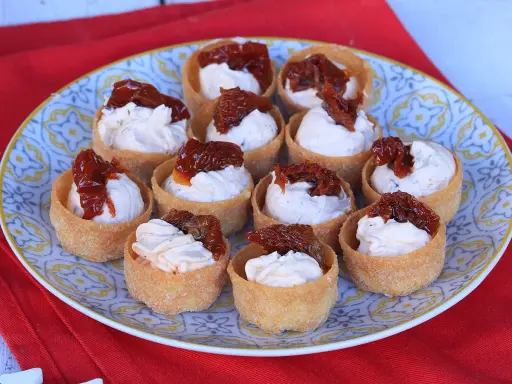 Antipasti veloci ed economici senza cottura: cestini croccanti ripieni di crema e pomodori secchi.