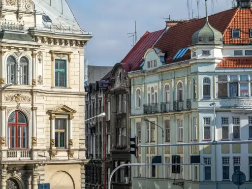 Kamienice na rynku w Bielsku-Białej, z bogatymi zdobieniami i różnorodnymi dachami, tworzą malowniczy widok.