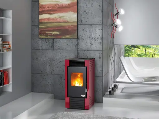Estufa de leña o pellets roja con fuego encendido, junto a una estantería blanca y un sillón curvo.