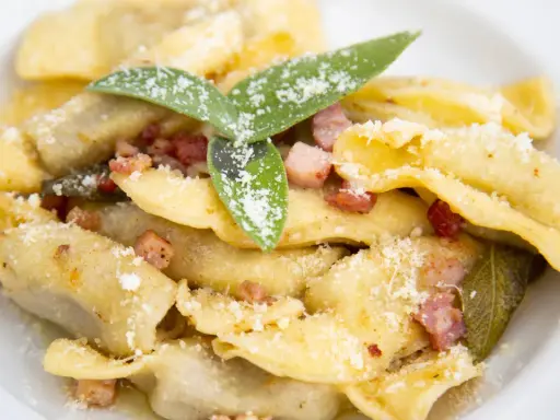 Ravioli fatti in casa con pancetta croccante, salvia e parmigiano, un assaggio dei piatti tipici bergamaschi.