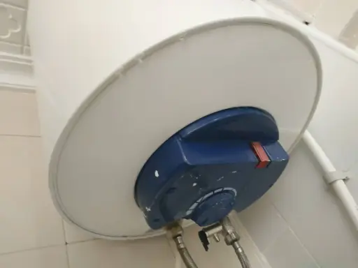 El termo gotea por abajo, mostrando una fuga de agua en la parte inferior del calentador.