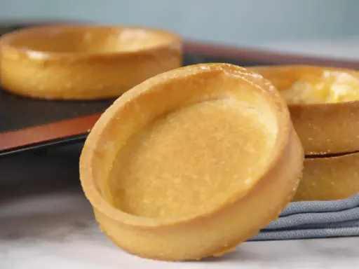 Fonds de tartelettes dorés, prêts pour une recette de pâte sucrée. Parfaits pour des desserts gourmands.