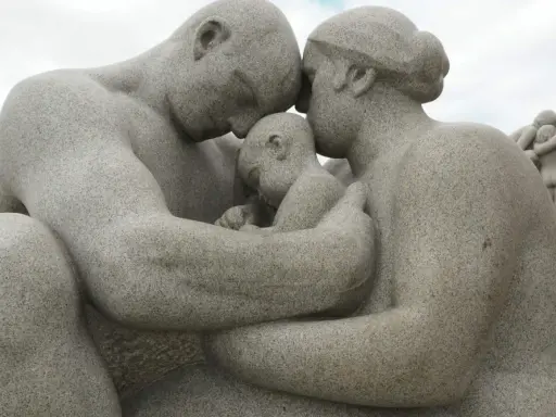Kamienna rodzina w parku w Oslo, czułe objęcia rodziców otulających dziecko.