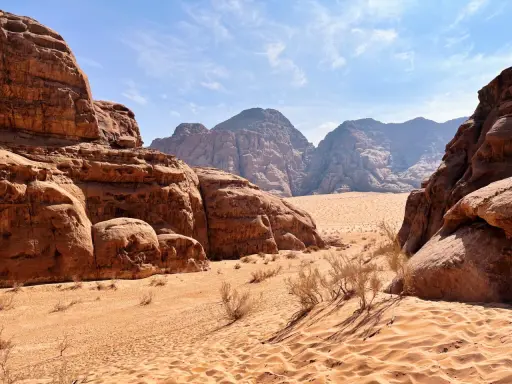 Pustynia w Jordanii, Wadi Rum. Piaskowe wydmy i skalne formacje pod błękitnym niebem.