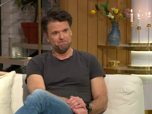 Peter Magnusson sitter i en soffa, kanske redo att prata om sina filmer och tv-program.
