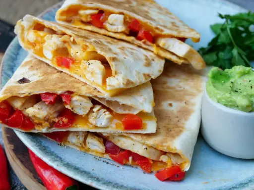Leckere Quesadillas mit Hähnchen, Paprika und Käse, dazu Guacamole. Ein tolles Quesadillas Rezept für jeden Anlass.