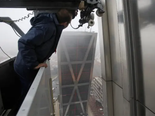 Un trabajador supervisa la construcción de las Torres KIO, inclinadas y emblemáticas de Madrid.