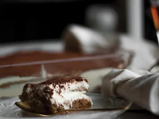 Kremowe tiramisu posypane kakao, idealne z odrobiną amaretto. Jaki alkohol do tiramisu? Ten deser zachwyca!