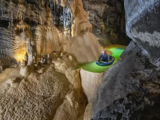 Explorador en balsa por el ojo guareña, un río subterráneo de aguas verdes y formaciones rocosas impresionantes.
