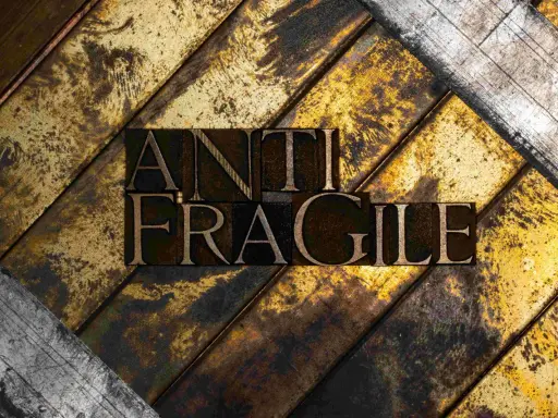 Lettere di metallo con la scritta "ANTI FRAGILE" su uno sfondo ruvido e dorato, simbolo di antifragilità e resilienza.